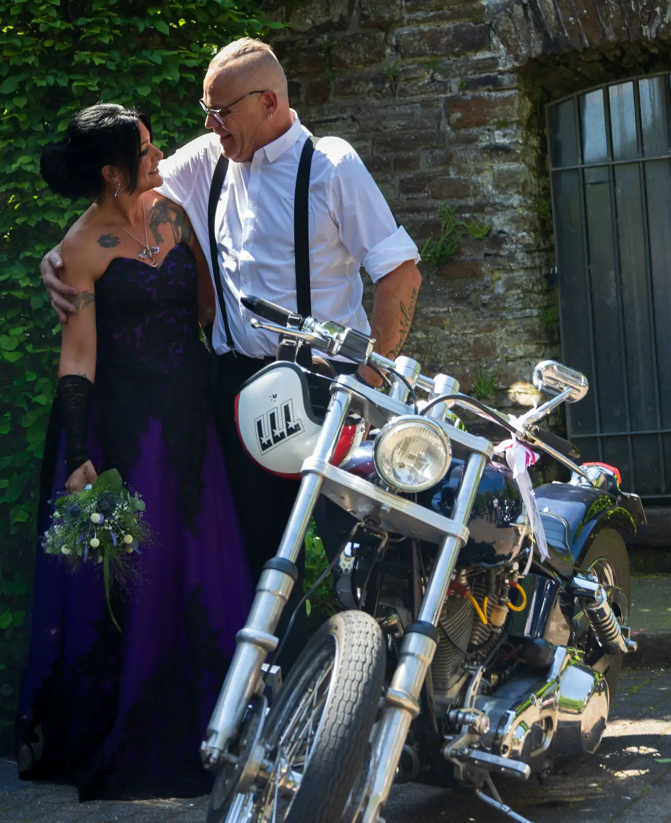 Brautpaar mit Motorrad vor einer Bruchsteinmauer Brautpaar mit Motorrad vor einer Bruchsteinmauer