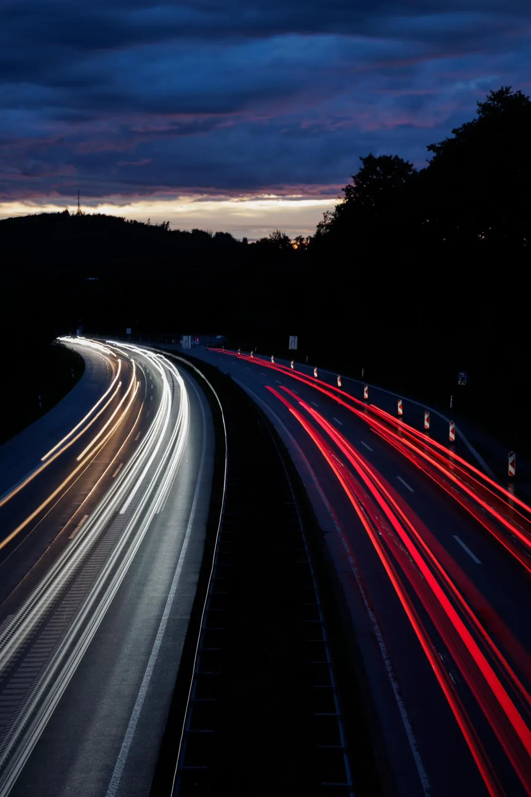 Langzeitaufnahme einer Straße bei Dämmerung mit weißen und roten Lichtspuren Langzeitaufnahme einer Straße bei Dämmerung mit weißen und roten Lichtspuren