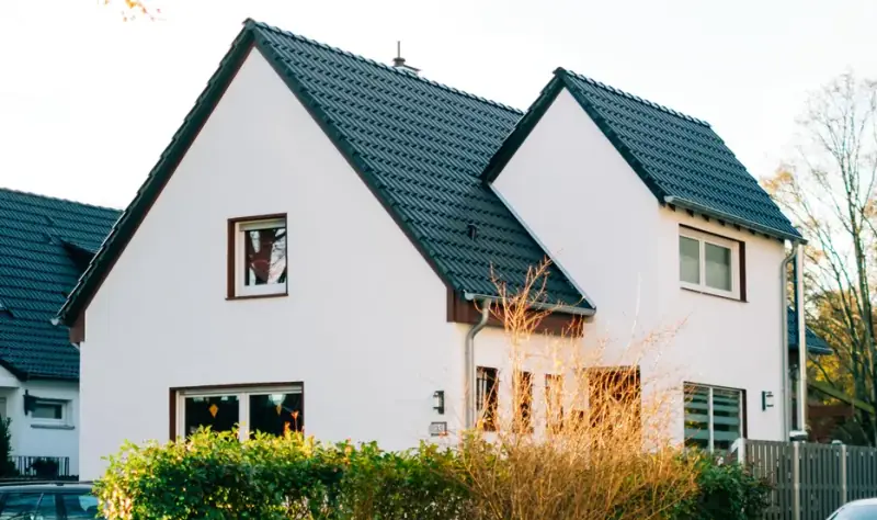 Freistehendes Einfamilienhaus mit weißer Fassade, Straßenansicht für Exposé und Vermarktung Freistehendes Einfamilienhaus mit weißer Fassade, Straßenansicht für Exposé und Vermarktung
